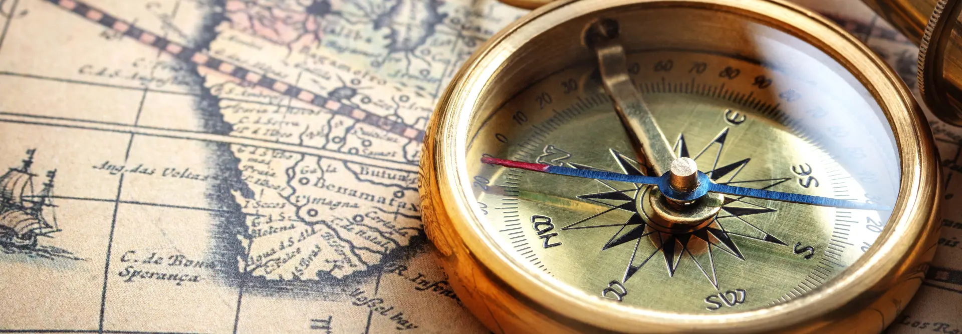 Vintage navigational compass on an old map, symbolizing the company's direction and long-standing presence in the corporate world.